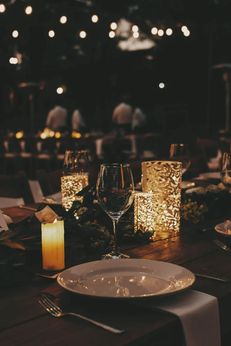 Candlelit dinner table with lanterns at an evening event