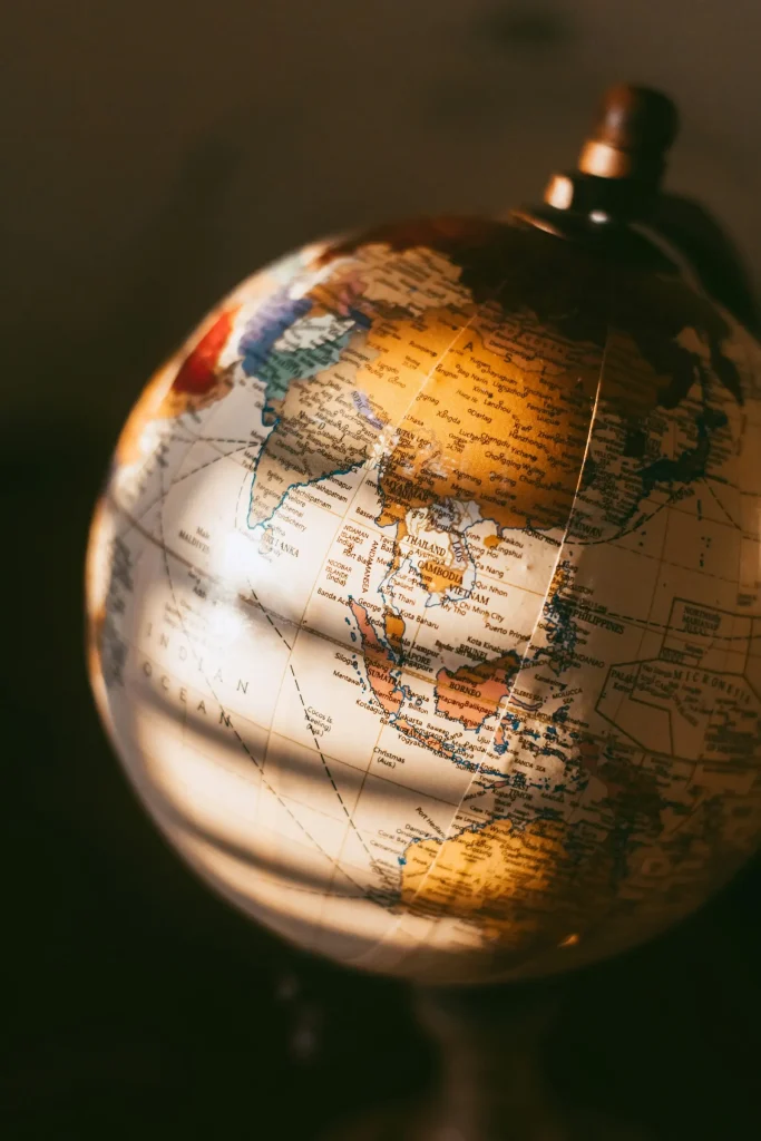 Warm sunlight falling in bands across a vintage desk globe