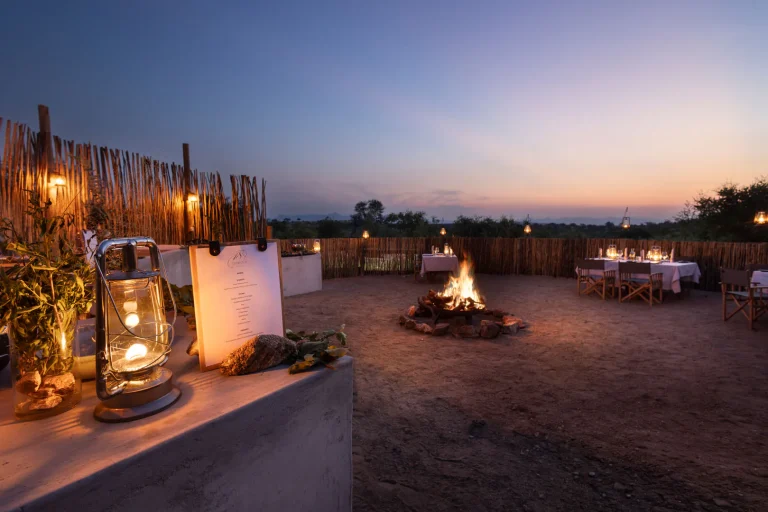 Boma dinner set around the fire at dusk