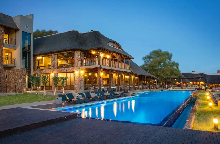 Aquila lodge and pool lit up at dusk