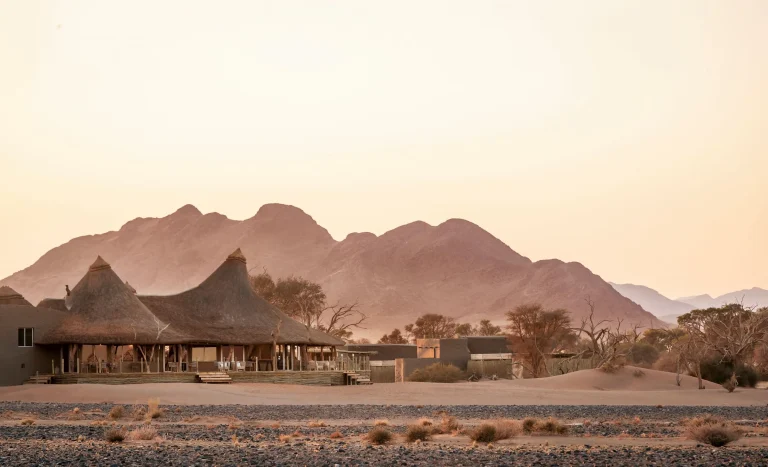Little Kulala's thatched villas below the mountains at dusk
