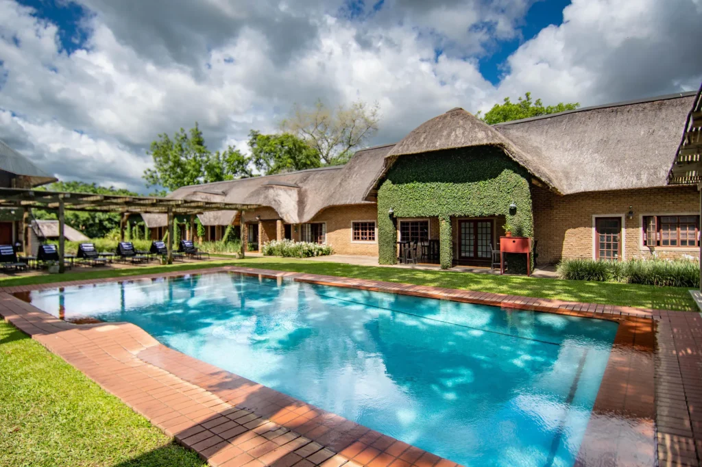 Pool and thatched cottages at Hippo Hollow