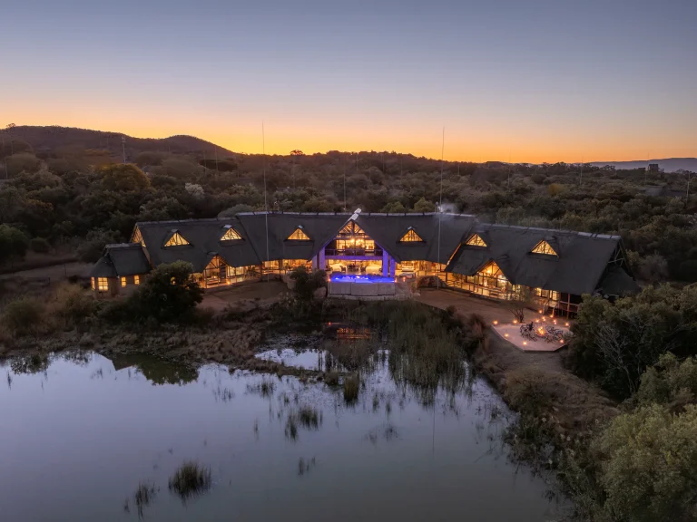 Kingfisher Villa lit up at dusk beside the dam