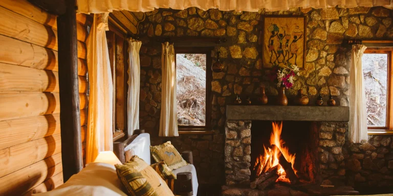 Log cabin with a stone fireplace at Mufindi Highlands Lodge