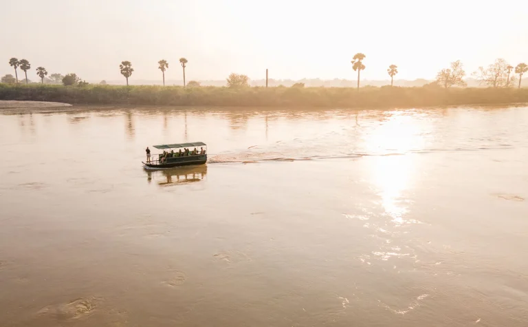 Safari boat on the misty Rufiji River at sunrise