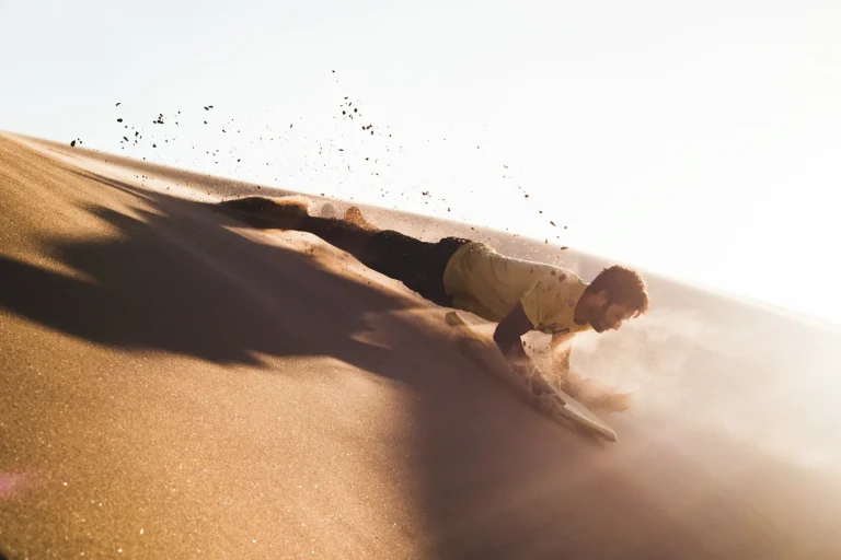 Sandboarding down a dune
